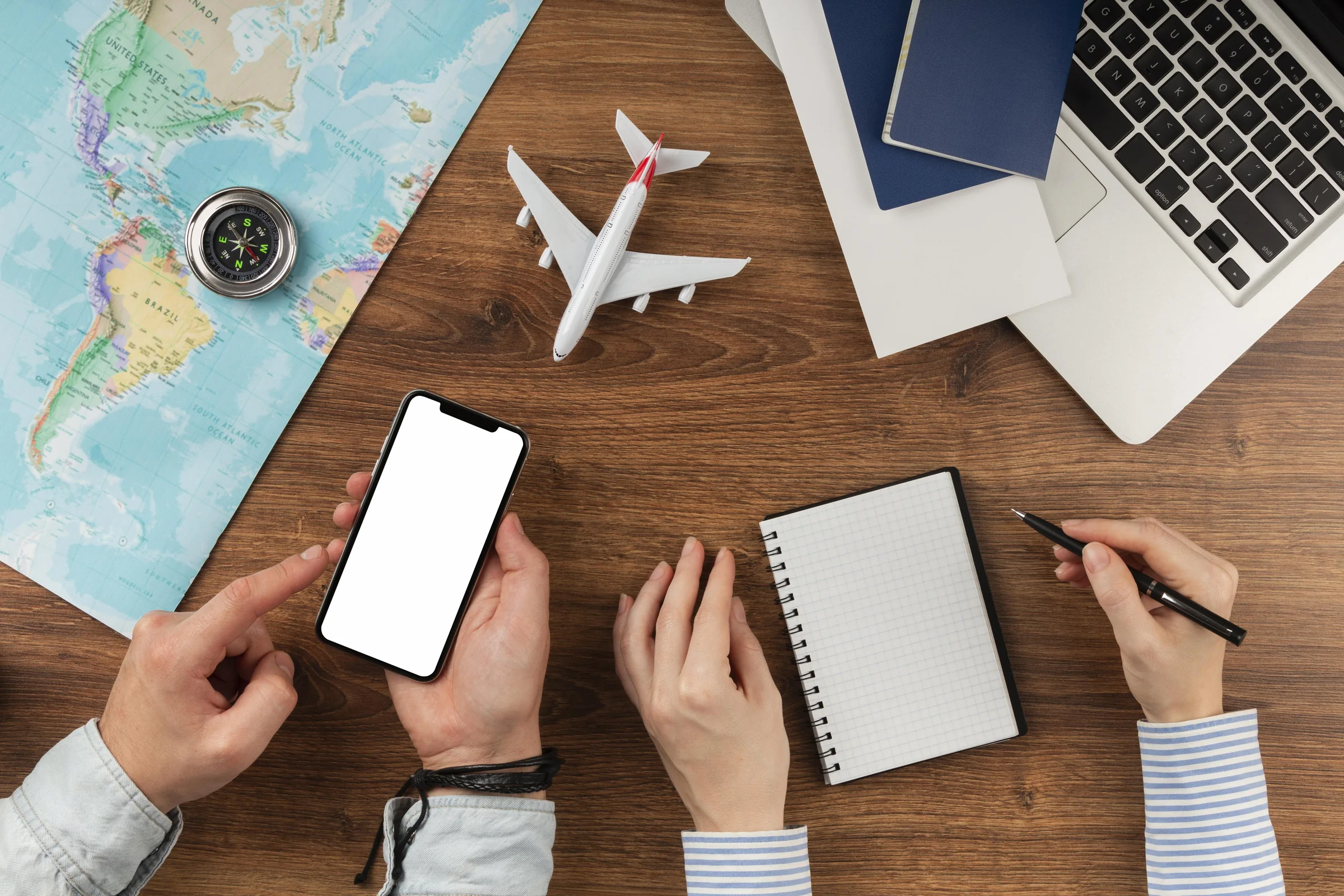 Travel planning on a desk: map, passport, phone and model plane